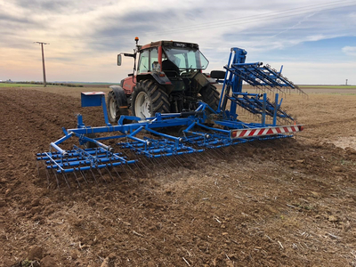 Photo de herse étrille sur une parcelle agricole, en fin de matinée