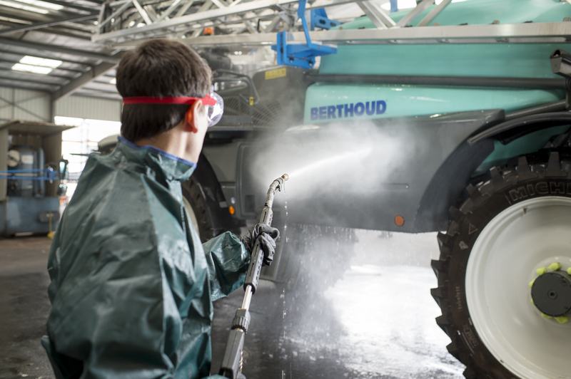 Agriculture en train de laver et rincer l'extérieur de son pulvérisateur